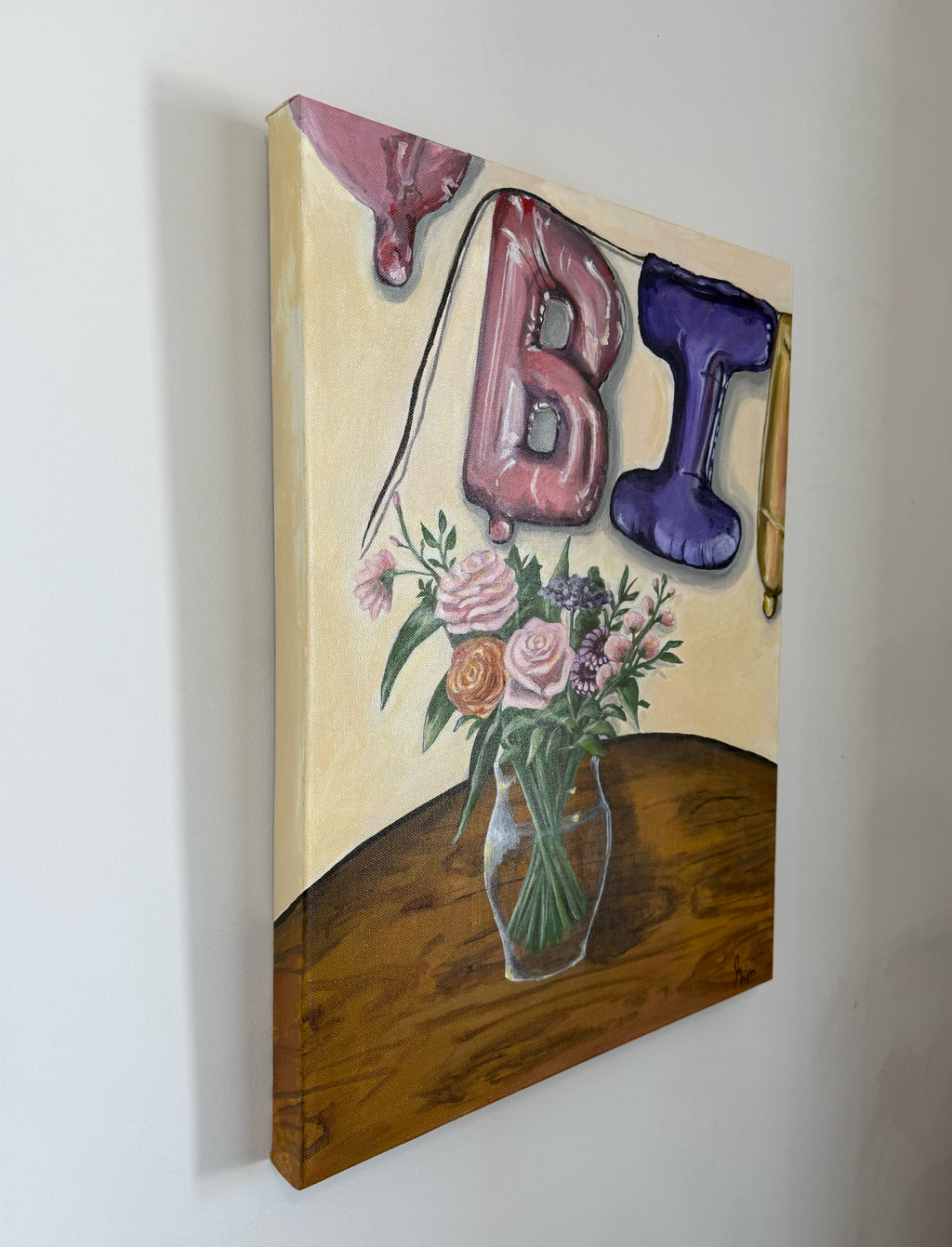 painting of decorative setup with balloon letters 'BI' and part of two other balloons and a vase of pink, purple, orange flowers and greenery in clear vase on a wooden table. view of the side of the painting.