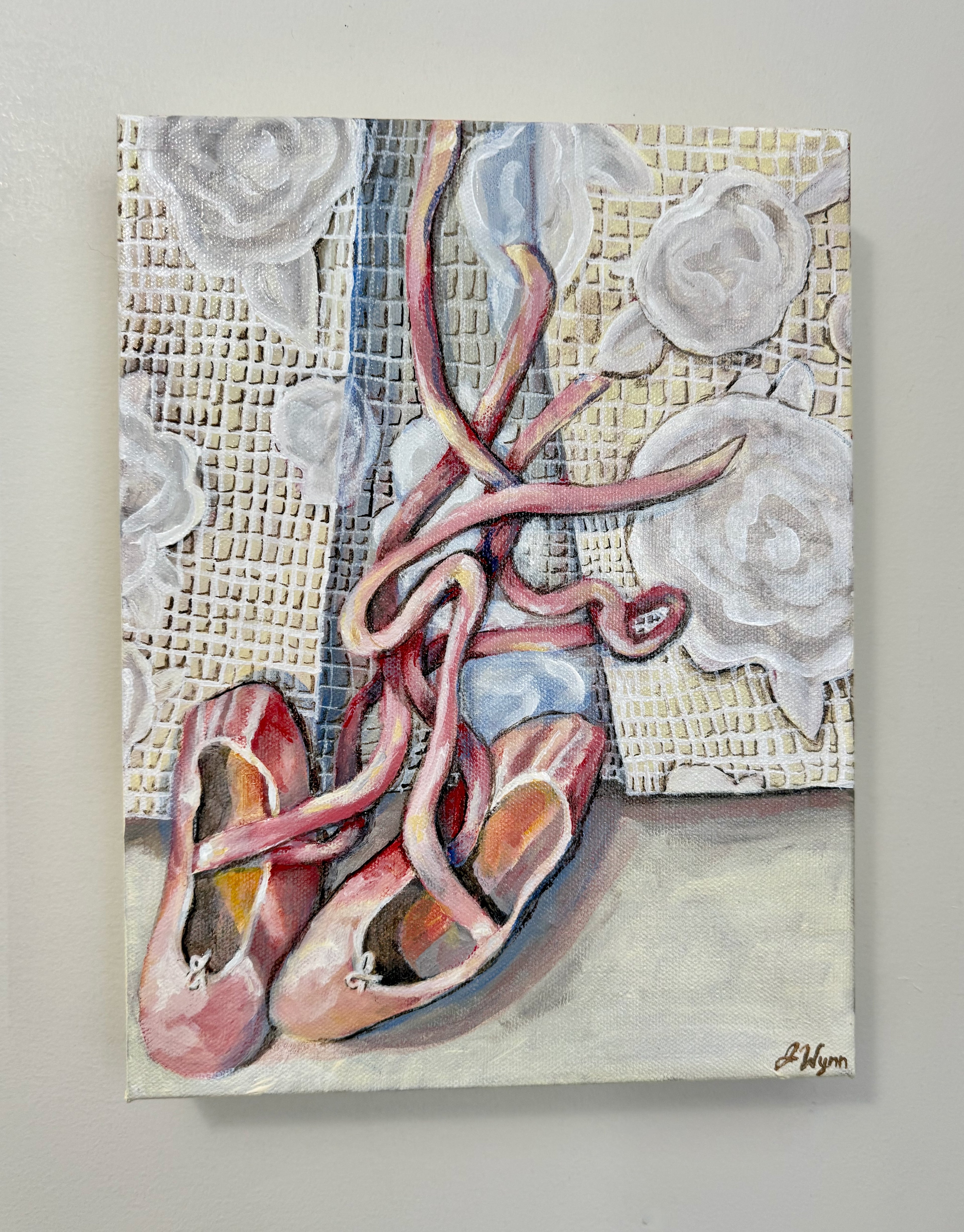 painting of pink ballet shoes with ribbons on a white lace textured background. view of painting on wall.