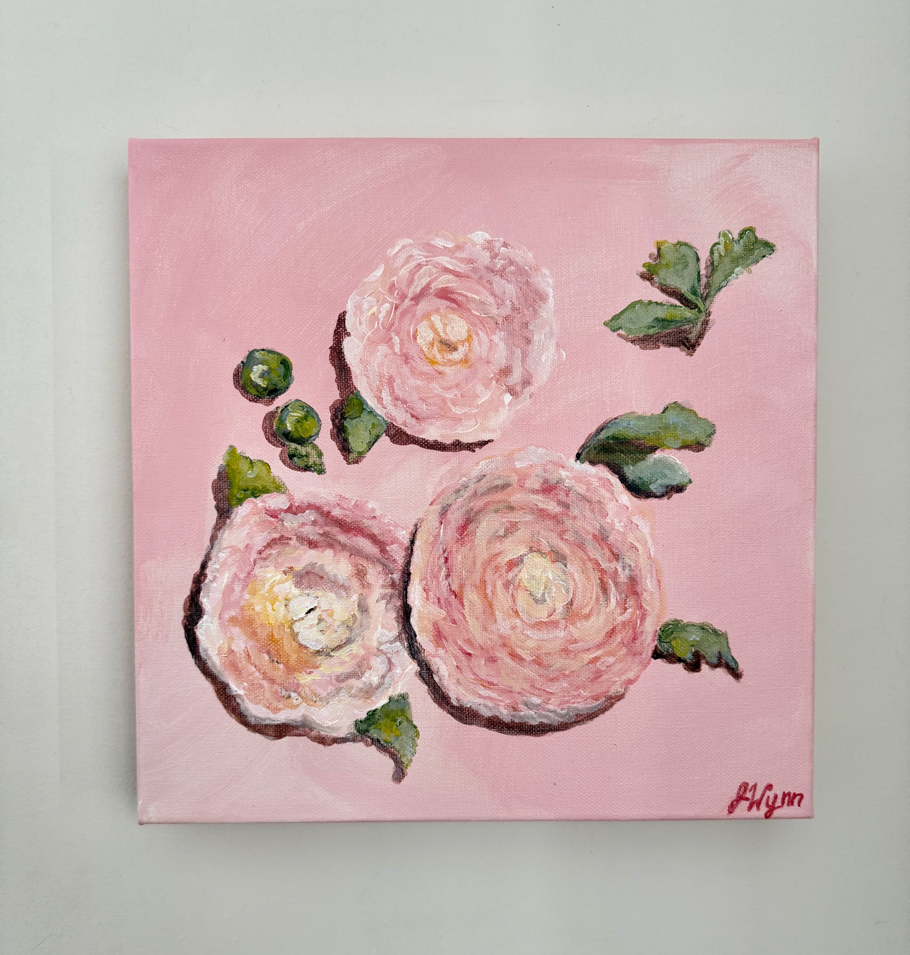 Painting of pink flowers with green leaves on a pink background. view of painting on wall.